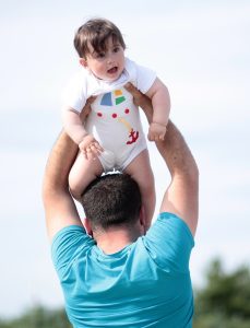 This image shows a father holding his son above his head. 