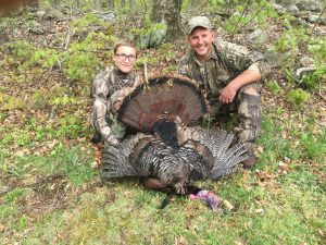 A man and his son posing next to a turkey in Pennsylvania