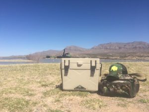 cooler, tackle box, and fishing rod for weekend fishing with a desert backdrop.