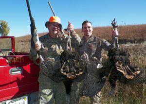 two men holding Kansas turkeys