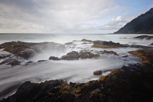 Thor's Well shrouded in mist and flowing with recent wave castoff