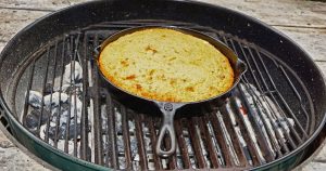 Cornbread cooking on a grill in a cast iron skillet to go with my secret chili recipe