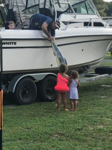 billy showing off his catch to the girls