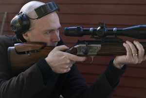 Man shooting a bolt action rifle
